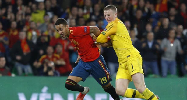 England's goalkeeper Jordan Pickford, right, tries to stop Spain's Rodrigo during the UEFA Nations League soccer match between Spain and England at Benito Villamarin stadium, in Seville, Spain, Monday, Oct. 15, 2018. (AP Photo/Miguel Morenatti)
